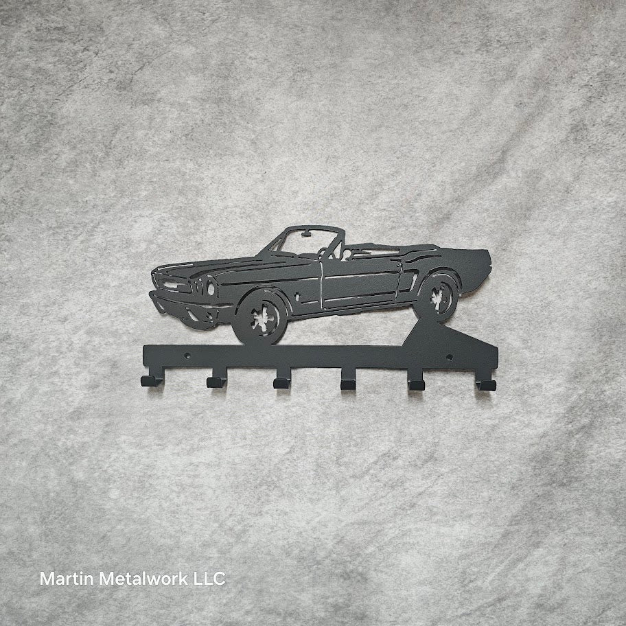 Metal car-shaped key holder on a gray fabric background with 'Martin Metalwork LLC' branding.